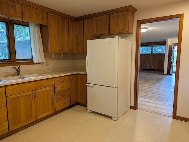 1437 S Plum Ave, Freeport, IL 61032 - kitchen with freestanding refrigerator, light countertops, plenty of natural light, and brown cabinets
