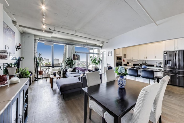1530 S State St Unit 14O, Chicago, IL 60605 - dining area with light wood-style floors, rail lighting, and a wall of windows