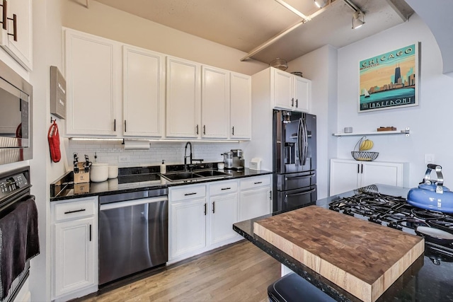 1530 S State St Unit 14O, Chicago, IL 60605 - kitchen featuring appliances with stainless steel finishes, white cabinetry, light wood-type flooring, tasteful backsplash, and dark stone countertops