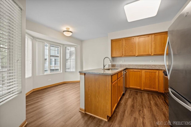 1916 Middlebury Dr Unit 1916, Aurora, IL 60503 - kitchen with stainless steel appliances, a peninsula, dark wood-style floors, and brown cabinets