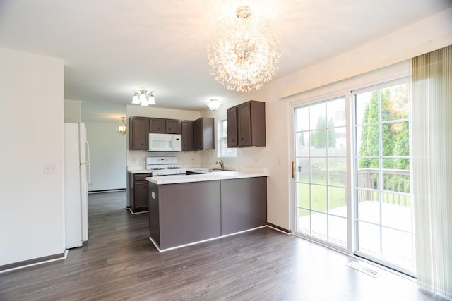 10 Sugar Creek Ct, Lake In The Hills, IL 60156 - kitchen with white appliances, a chandelier, dark brown cabinetry, a peninsula, and healthy amount of natural light