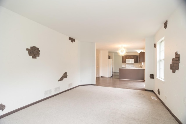 10 Sugar Creek Ct, Lake In The Hills, IL 60156 - unfurnished living room with dark carpet and a chandelier