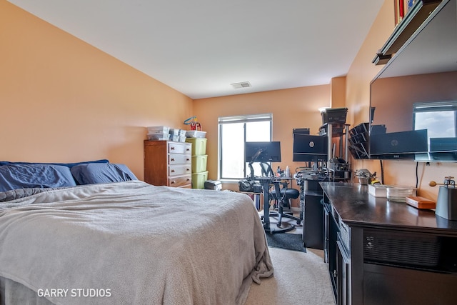 carpeted bedroom with an office area