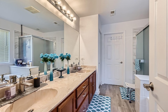 233 Pawtucket Ave, Elgin, IL 60124 - bathroom featuring a stall shower, wood finished floors, and double vanity