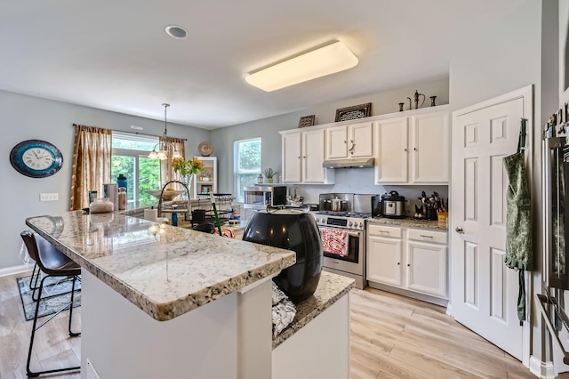 233 Pawtucket Ave, Elgin, IL 60124 - kitchen with gas stove, under cabinet range hood, white cabinetry, and light wood-type flooring