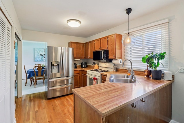 5506 W Chasefield Cir, Mchenry, IL 60050 - kitchen with stainless steel refrigerator with ice dispenser, white range with gas cooktop, a peninsula, light wood finished floors, and brown cabinetry