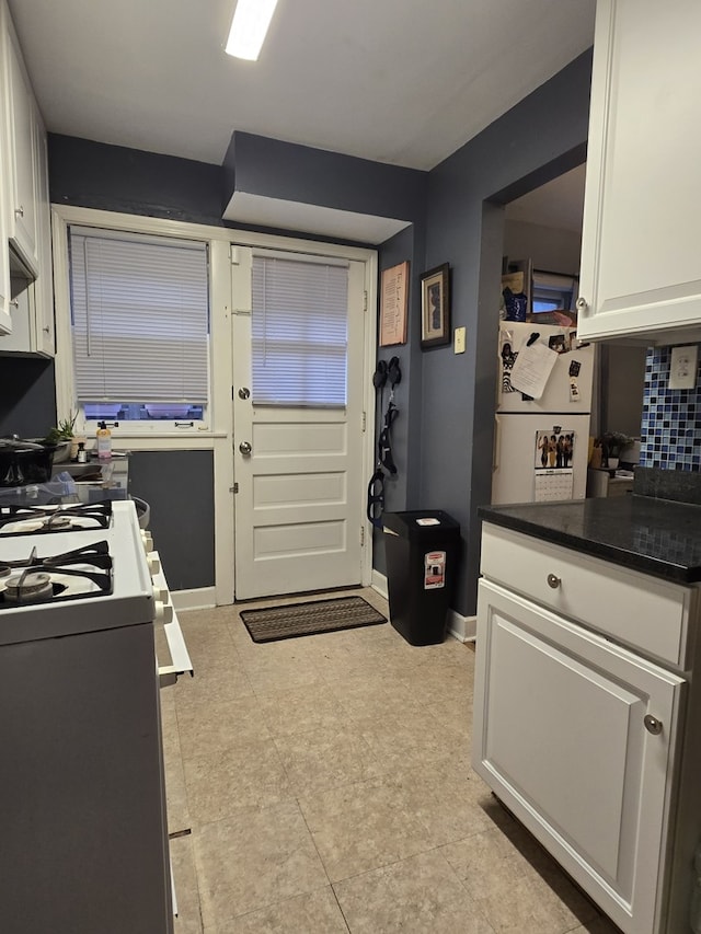 1007 S Oak Park Ave Unit E, Oak Park, IL 60304 - kitchen with white appliances, white cabinets, dark countertops, decorative backsplash, and light flooring
