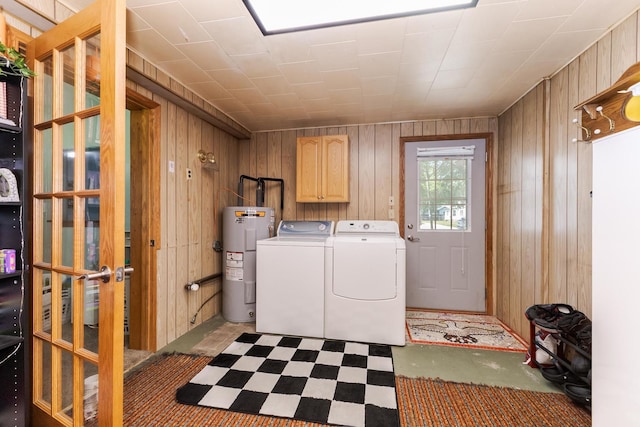 1014 N Main St, Pontiac, IL 61764 - laundry area with electric water heater, cabinet space, wood walls, washer and dryer, and light floors