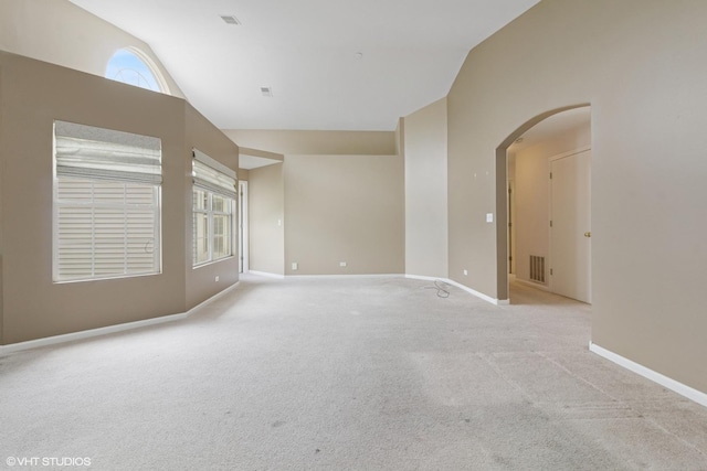 406 Cascade Ln Unit 406, Oswego, IL 60543 - spare room with lofted ceiling, arched walkways, healthy amount of natural light, and light carpet