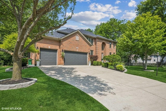 8736 Shade Tree Cir, Lakewood, IL 60014 - traditional-style home featuring driveway, brick siding, an attached garage, and a front lawn