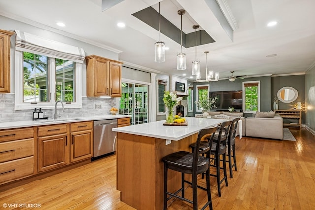 8736 Shade Tree Cir, Lakewood, IL 60014 - kitchen with dishwasher, crown molding, light countertops, a breakfast bar area, and light wood-style flooring
