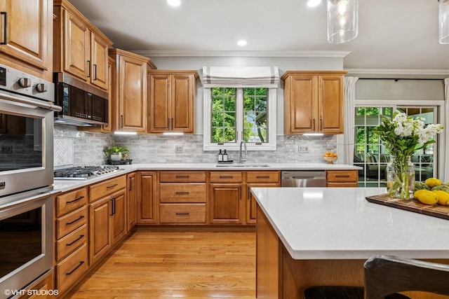 8736 Shade Tree Cir, Lakewood, IL 60014 - kitchen featuring stainless steel appliances, crown molding, light wood-style flooring, light countertops, and tasteful backsplash