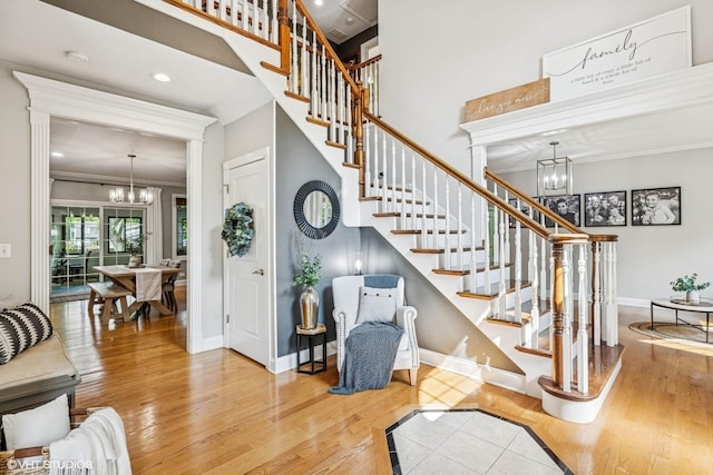 8736 Shade Tree Cir, Lakewood, IL 60014 - stairs featuring a chandelier, wood finished floors, ornamental molding, a towering ceiling, and recessed lighting
