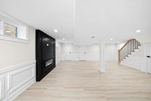 5246 S New England Ave, Chicago, IL 60638 - below grade area featuring a decorative wall, a fireplace, light wood finished floors, stairway, and wainscoting