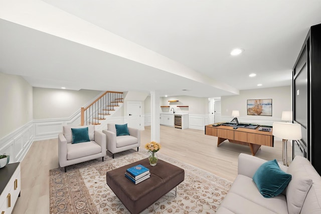 5246 S New England Ave, Chicago, IL 60638 - living area with ornate columns, light wood-type flooring, a decorative wall, wainscoting, and stairs