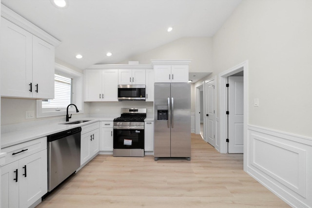 5246 S New England Ave, Chicago, IL 60638 - kitchen with appliances with stainless steel finishes, lofted ceiling, white cabinets, a wainscoted wall, and light countertops