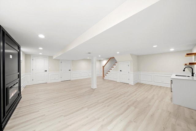 5246 S New England Ave, Chicago, IL 60638 - finished basement with a decorative wall, a wainscoted wall, light wood-style flooring, a large fireplace, and stairs