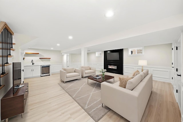 5246 S New England Ave, Chicago, IL 60638 - living area featuring wine cooler, a glass covered fireplace, light wood finished floors, a decorative wall, and bar area
