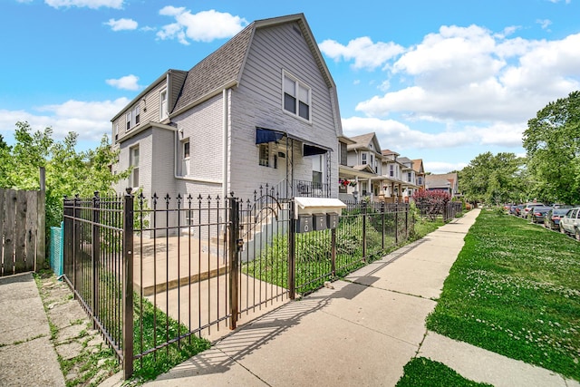 4125 W School St, Chicago, IL 60641 - view of property exterior with a residential view, a fenced front yard, roof with shingles, a gambrel roof, and a gate