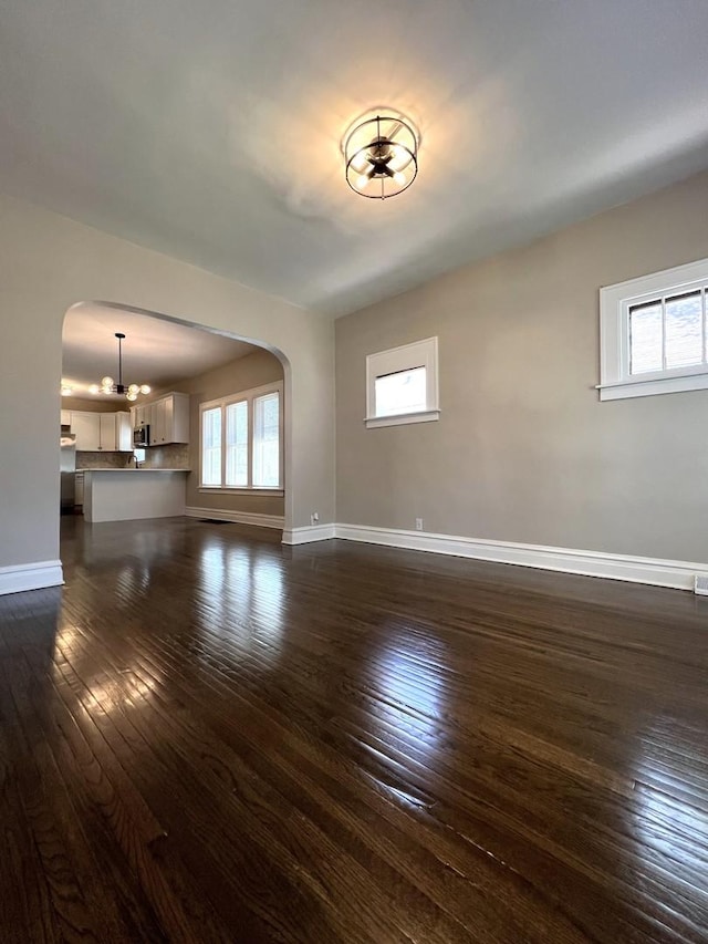 120 S May St, Joliet, IL 60436 - unfurnished living room with arched walkways and dark wood-style flooring