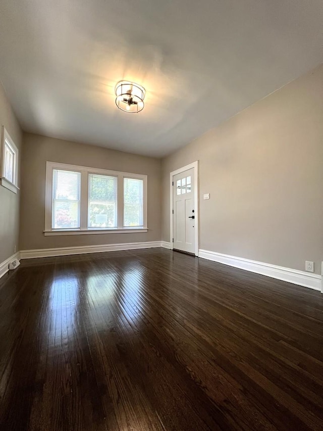 120 S May St, Joliet, IL 60436 - unfurnished living room featuring baseboards and dark wood-style flooring