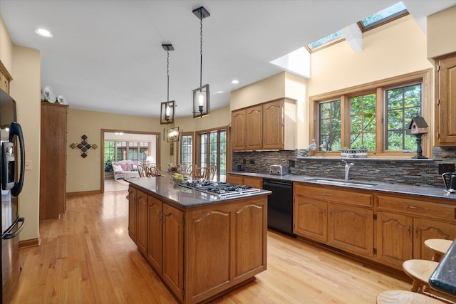 8 Buckingham Dr, Sugar Grove, IL 60554 - kitchen with stainless steel appliances, a center island, decorative backsplash, brown cabinets, and light wood-style flooring