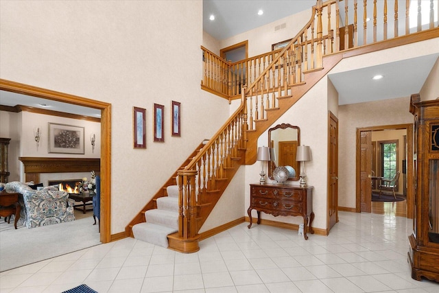8 Buckingham Dr, Sugar Grove, IL 60554 - stairs featuring a high ceiling, a warm lit fireplace, tile patterned flooring, and recessed lighting