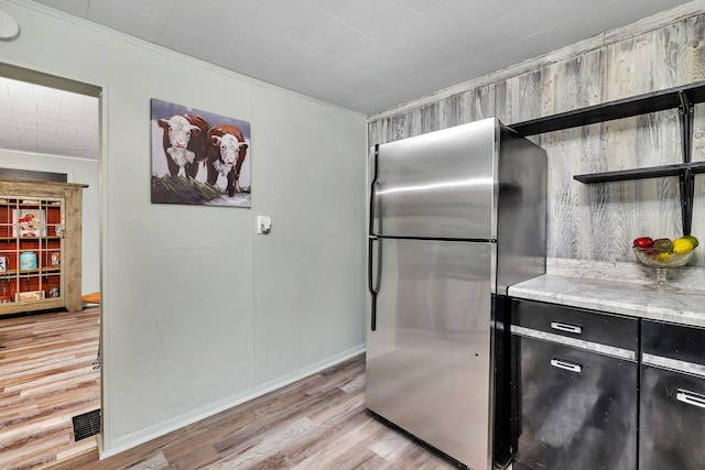 607 E Bridge St, Streator, IL 61364 - kitchen with freestanding refrigerator, open shelves, light wood-style floors, and dark cabinets
