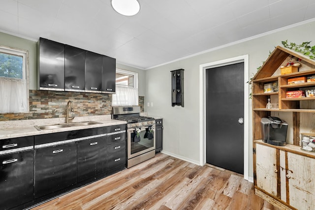607 E Bridge St, Streator, IL 61364 - kitchen featuring stainless steel gas range oven, dark cabinets, crown molding, light wood-style flooring, and backsplash