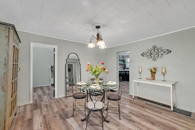 607 E Bridge St, Streator, IL 61364 - dining area with ornamental molding, light wood-style flooring, arched walkways, and a chandelier