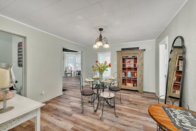 607 E Bridge St, Streator, IL 61364 - dining area with ornamental molding, light wood-type flooring, and a chandelier