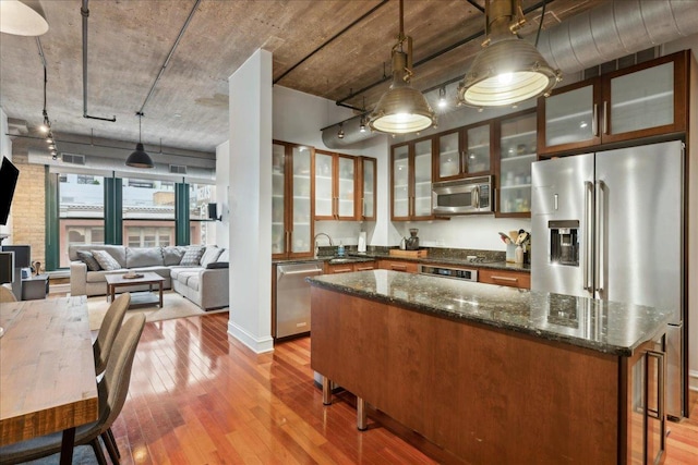 411 W Ontario St Unit 411, Chicago, IL 60654 - kitchen with appliances with stainless steel finishes, light wood-type flooring, glass insert cabinets, and a kitchen island
