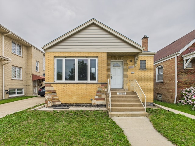 3810 W 71st St, Chicago, IL 60629 - bungalow with brick siding, entry steps, a front yard, and a chimney