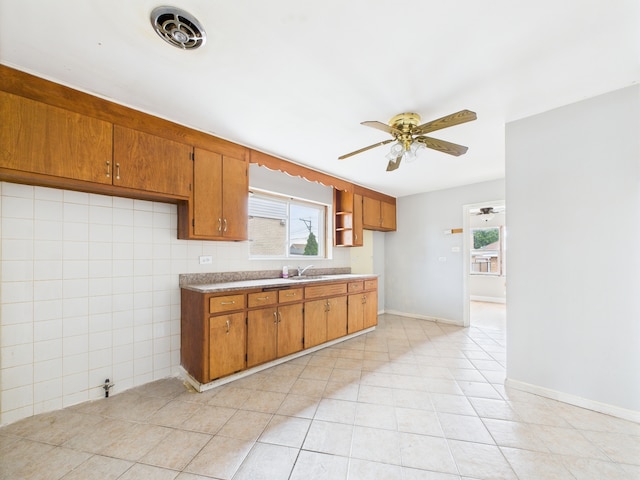 3810 W 71st St, Chicago, IL 60629 - kitchen featuring brown cabinets, ceiling fan, light tile patterned floors, and light countertops