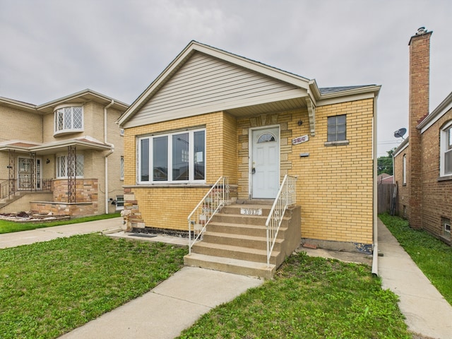 3810 W 71st St, Chicago, IL 60629 - view of front of home featuring brick siding, a front yard, and entry steps