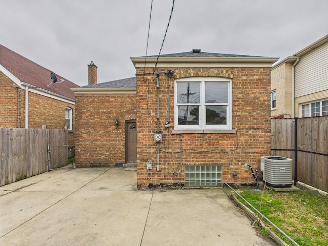 3810 W 71st St, Chicago, IL 60629 - back of house featuring a patio area, brick siding, a fenced backyard, a chimney, and a shingled roof