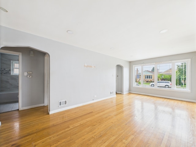 3810 W 71st St, Chicago, IL 60629 - unfurnished living room with arched walkways and light wood-style flooring