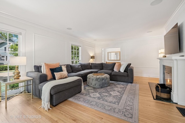 720 Willow Rd, Winnetka, IL 60093 - living room featuring healthy amount of natural light, crown molding, light wood-style flooring, a decorative wall, and a fireplace with flush hearth