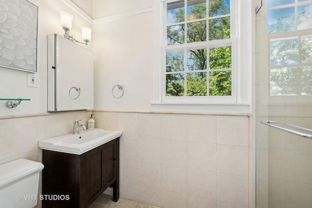 720 Willow Rd, Winnetka, IL 60093 - bathroom featuring tile walls, vanity, a tile shower, and wainscoting