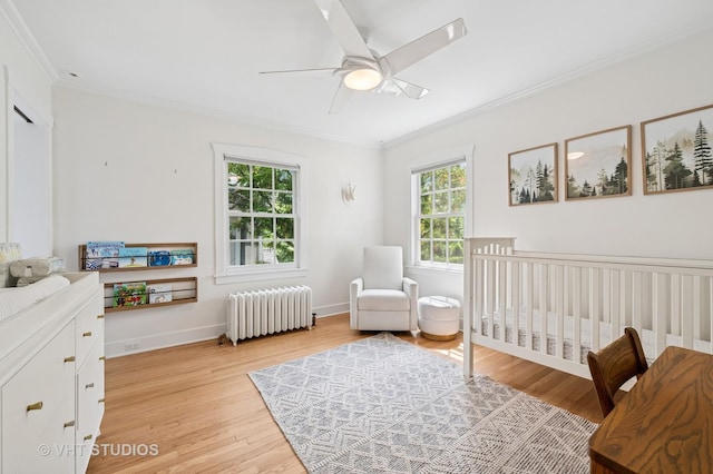 720 Willow Rd, Winnetka, IL 60093 - bedroom with radiator heating unit, ornamental molding, light wood-style flooring, a nursery area, and ceiling fan