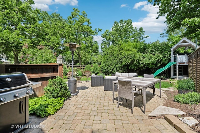 720 Willow Rd, Winnetka, IL 60093 - fenced backyard with grilling area, a patio area, a playground, outdoor dining space, and view of wooded area