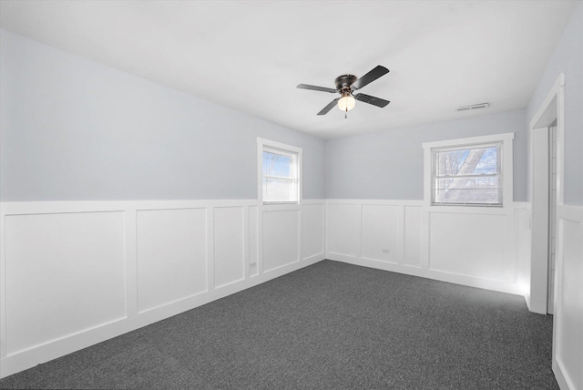 329 Blackhawk Dr, Park Forest, IL 60466 - empty room with dark carpet, wainscoting, ceiling fan, and a decorative wall