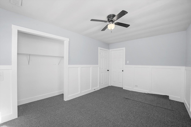 329 Blackhawk Dr, Park Forest, IL 60466 - unfurnished bedroom with dark carpet, wainscoting, ceiling fan, and a decorative wall