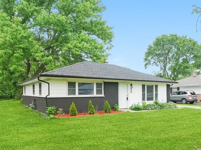 329 Blackhawk Dr, Park Forest, IL 60466 - view of front facade featuring a front yard, brick siding, a chimney, and roof with shingles