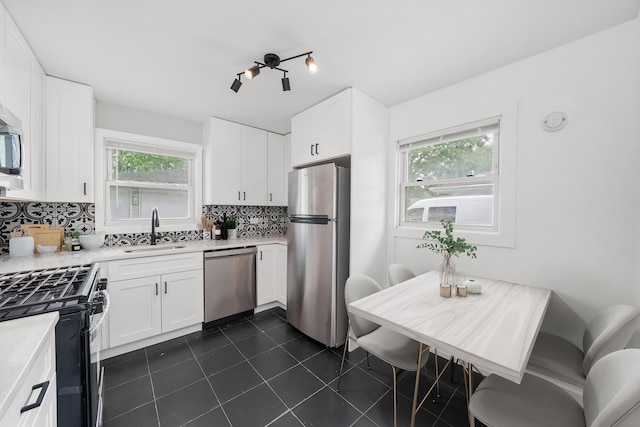 329 Blackhawk Dr, Park Forest, IL 60466 - kitchen featuring stainless steel appliances, backsplash, dark tile patterned floors, light countertops, and white cabinets