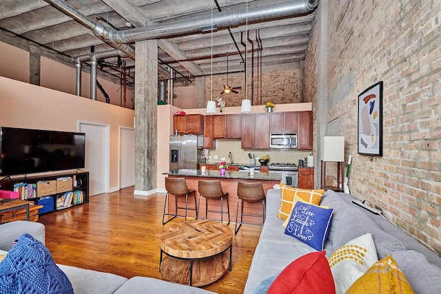 2545 S Dearborn St Unit 323, Chicago, IL 60616 - living room featuring a towering ceiling, wood finished floors, and brick wall
