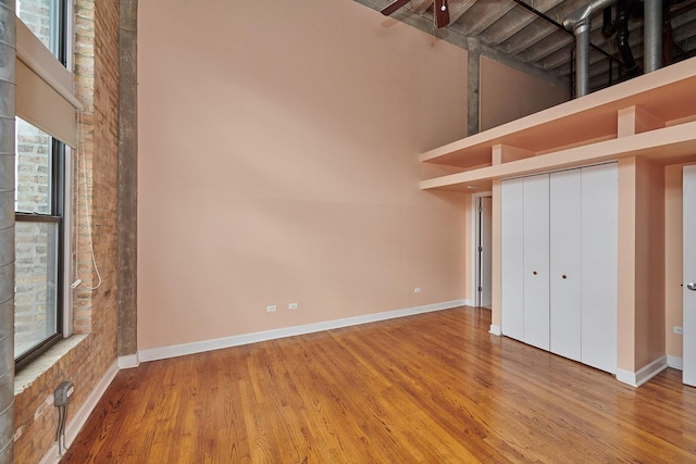 2545 S Dearborn St Unit 323, Chicago, IL 60616 - unfurnished bedroom with wood finished floors, a towering ceiling, and a closet