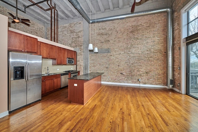 2545 S Dearborn St Unit 323, Chicago, IL 60616 - kitchen featuring appliances with stainless steel finishes, a high ceiling, brick wall, ceiling fan, and light wood-type flooring
