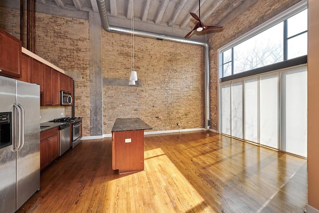 2545 S Dearborn St Unit 323, Chicago, IL 60616 - kitchen with appliances with stainless steel finishes, brick wall, a high ceiling, ceiling fan, and dark wood-type flooring