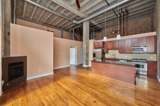 2545 S Dearborn St Unit 323, Chicago, IL 60616 - kitchen with a towering ceiling, appliances with stainless steel finishes, pendant lighting, backsplash, and light wood finished floors